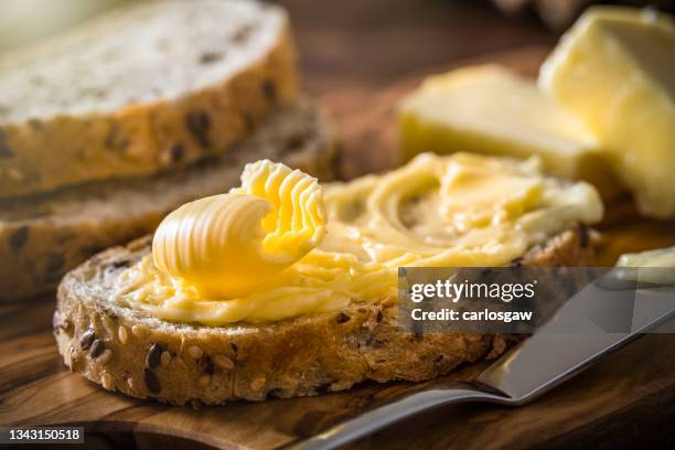 slice of bread with butter curl - bread butter stock pictures, royalty-free photos & images