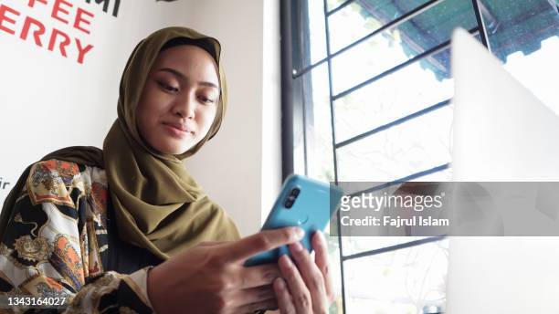 asian hijab women using smartphone - fajrul islam stock pictures, royalty-free photos & images