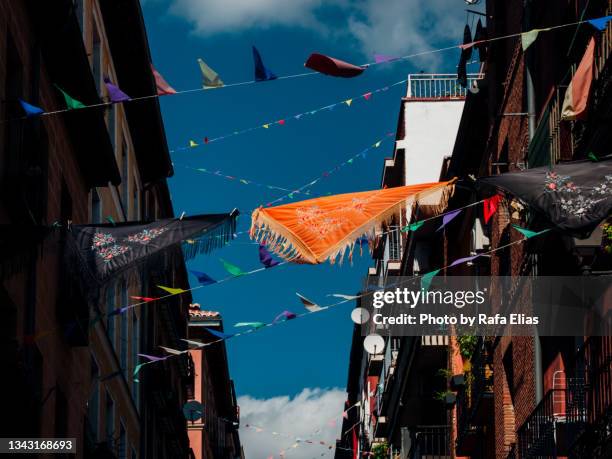 street decorated with hanging shawls and colorful pennants, city festivities - street style in madrid stock pictures, royalty-free photos & images