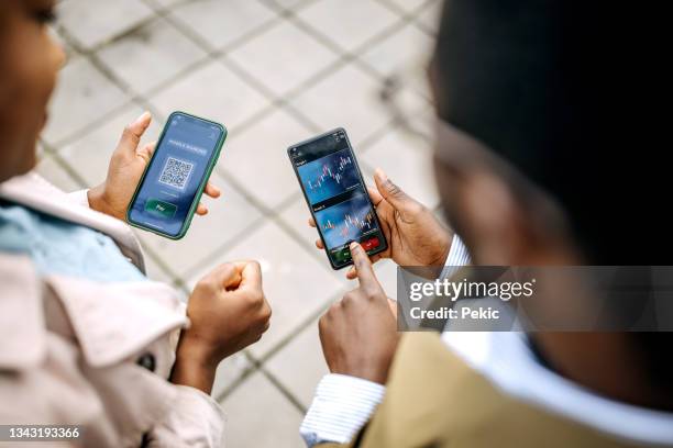 young colleagues checking their crypto investment app - assessment graph stock pictures, royalty-free photos & images