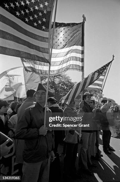 An angry-looking man in faux-colonial attire carries an American flag in South Boston's Columbus Park at a march to protest federal court-ordered...