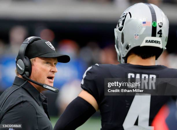 Head coach Jon Gruden of the Las Vegas Raiders talks with quarterback Derek Carr during their game against the Miami Dolphins at Allegiant Stadium on...