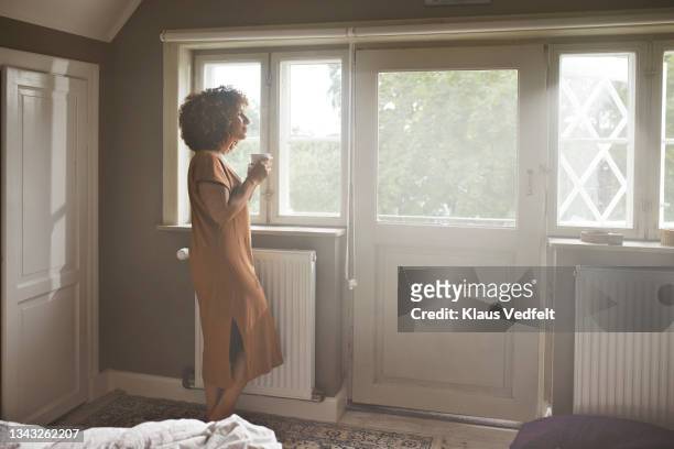 woman with coffee cup at home - beige dress stock pictures, royalty-free photos & images