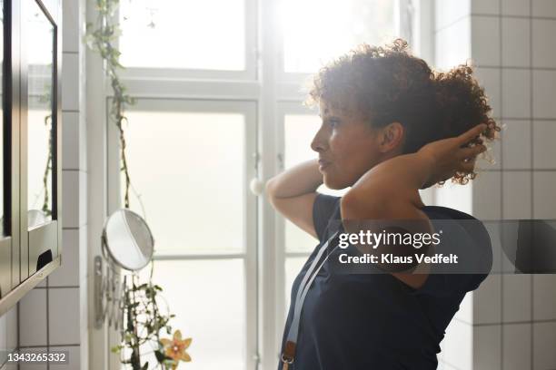 healthcare worker getting dressed up - hand in hair stock pictures, royalty-free photos & images