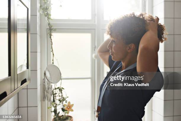 home caregiver tying hair - porter photos et images de collection