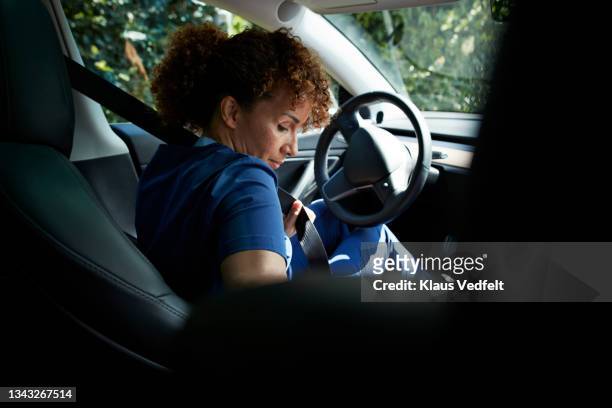female caregiver fastening seat belt - abrochar fotografías e imágenes de stock