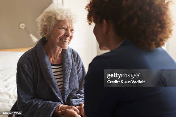 senior woman talking with nurse - pflegedienst blau stock-fotos und bilder