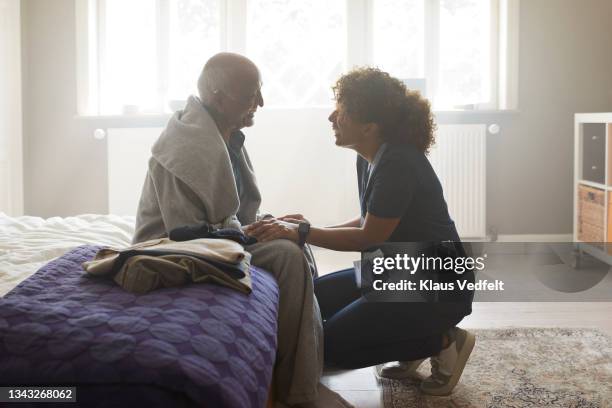 nurse talking with senior man - wrapped in a blanket stock pictures, royalty-free photos & images