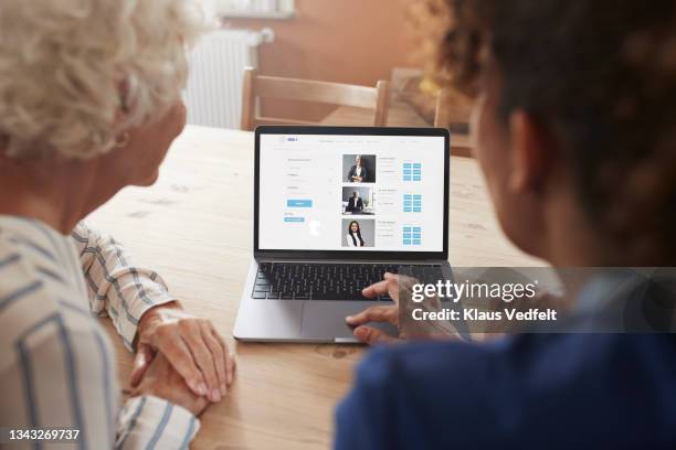 nurse teaching woman booking online appointment - old monitor computer stock-fotos und bilder