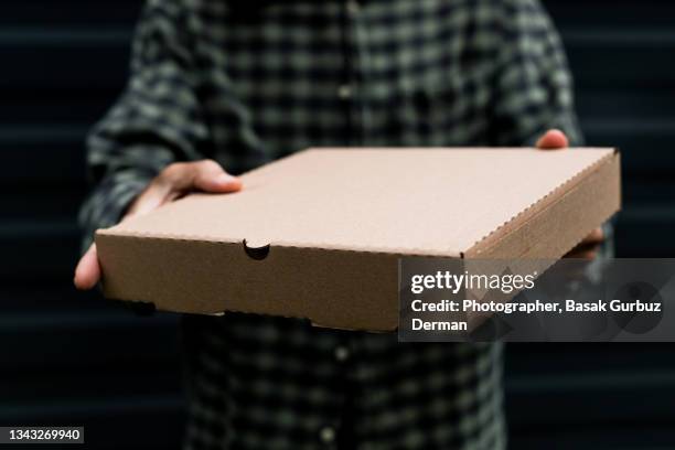 a man holding, delivering a cardboard box - pizzaschachtel stock-fotos und bilder