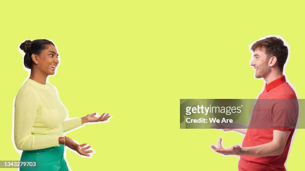 young man and woman having conversation against yellow background - talking stock pictures, royalty-free photos & images