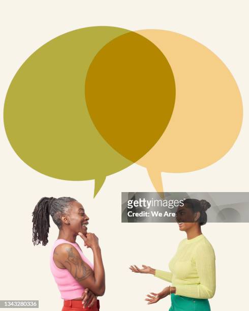 two women talking with speech bubbles - business forum in london stock-fotos und bilder