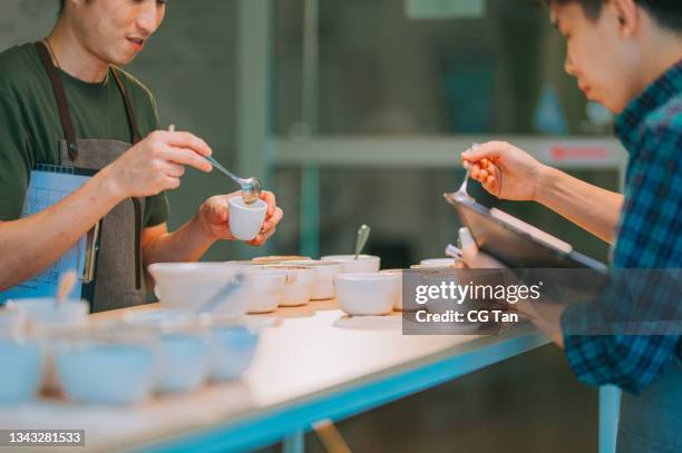 asian chinese barista connoisseur scooping coffee ground cleaning for coffee cupping tasting scope - taste test stock pictures, royalty-free photos & images