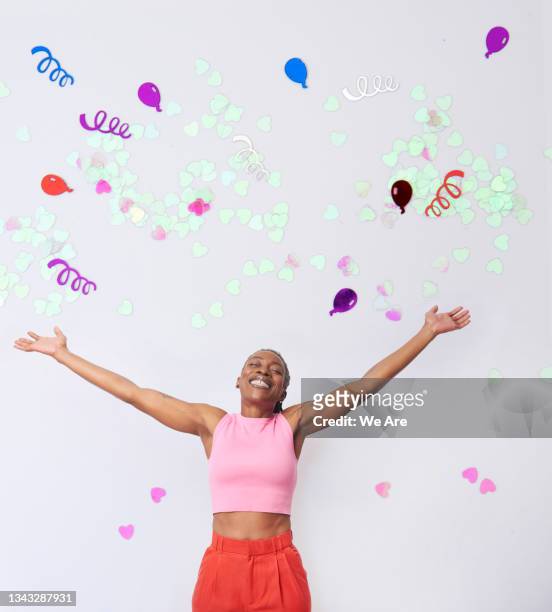 collage of mature woman with arms outstretched celebrating surrounded by confetti - celebrating win stock-fotos und bilder