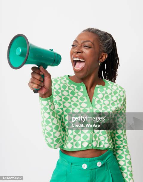 mature woman shouting into megaphone - activists stock-fotos und bilder