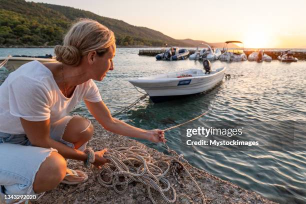 joven atracando barco de madera al atardecer - cabo característica costera fotografías e imágenes de stock