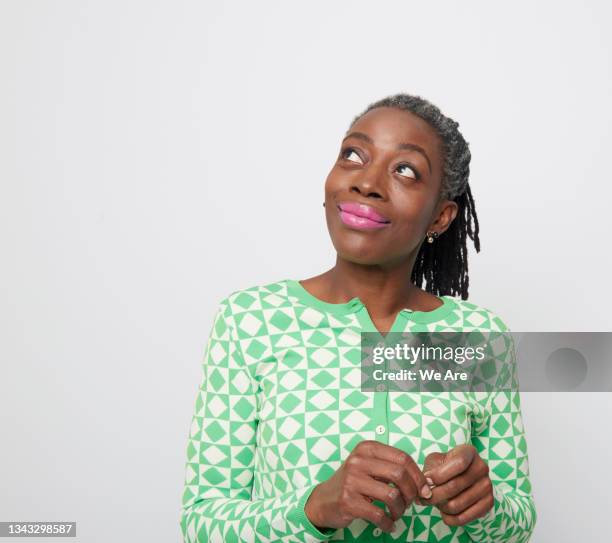 portrait of mature woman looking up in contemplation - regard de côté studio photos et images de collection