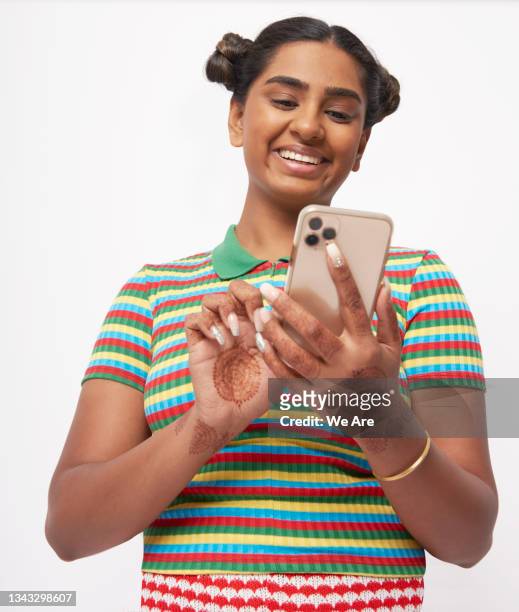 young woman in striped top, using smartphone smiling - mobile phone reading low angle stock-fotos und bilder