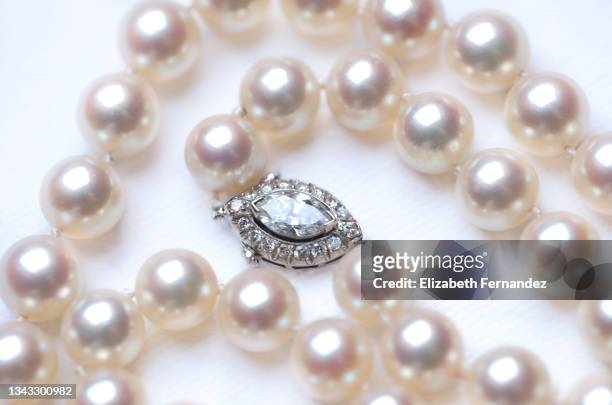 pearl necklace with diamond clasp on white background - pearl necklace stockfoto's en -beelden
