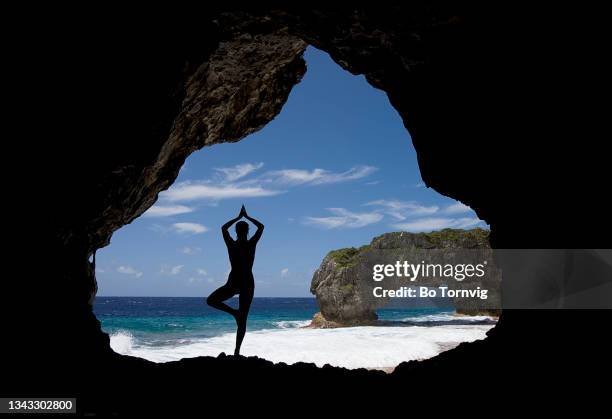 young woman doing yoga in a cave - bo tornvig photos et images de collection