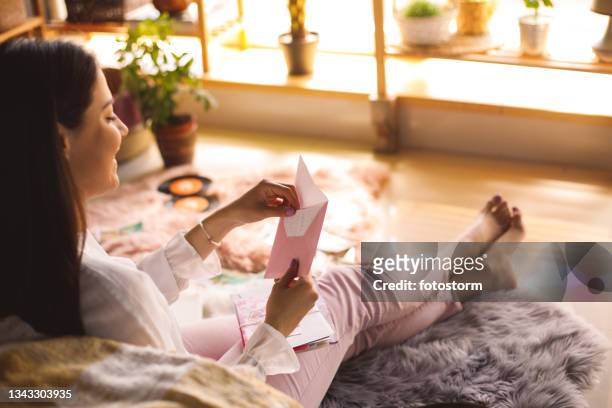 young woman opening a love letter from her partner - love letter 個照片及圖片檔