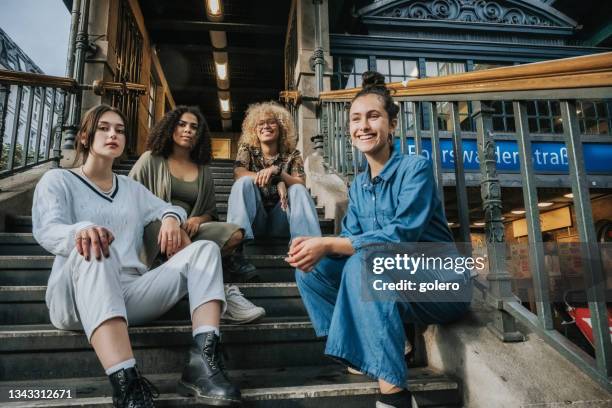 four young smiling woman in berlin sitting on stairs of subway station in berlin - berlin subway stock pictures, royalty-free photos & images