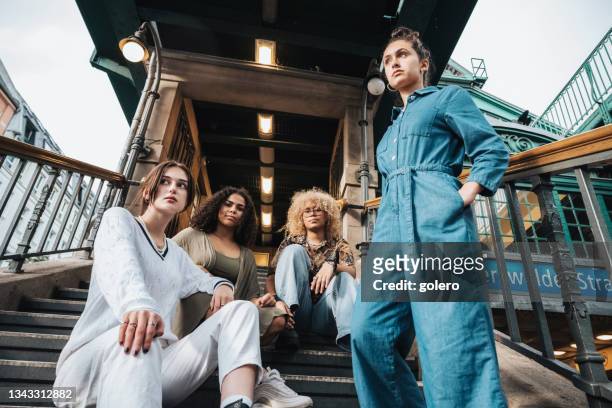 vier junge frau in berlin auf treppen der berliner u-bahn-station - fashion stock-fotos und bilder