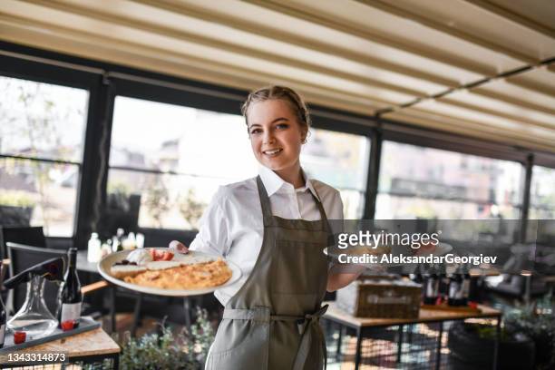 レストランで朝食オムレツプレートを運ぶ笑顔のブロンドウェイトレス - ウエイトレス ス��トックフォトと画像