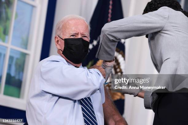 President Joe Biden receives a third dose of the Pfizer/BioNTech Covid-19 vaccine in the South Court Auditorium in the White House September 27, 2021...