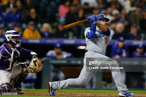 Max Muncy of the Los Angeles Dodgers hits an RBI single as catcher Elias Diaz of the Colorado Rockies looks on in the fifth inning at Coors Field on...