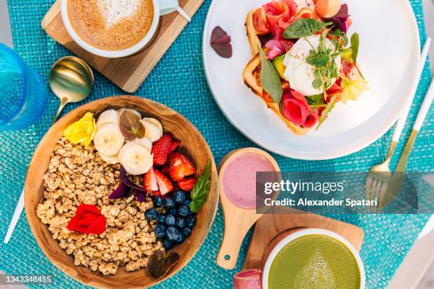 healthy breakfast with smoothie bowl and waffle with salmon and poached egg - blue bowl stockfoto's en -beelden