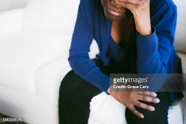 woman in distress sits on couch - unrecognisable person stock pictures, royalty-free photos & images