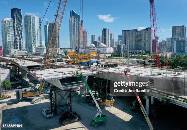 In an aerial view, construction workers build the “Signature Bridge,” at I-95 and I-395 that replaces an older bridge on September 27, 2021 in Miami,...
