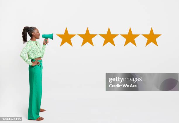 composite image of mature woman holding megaphone with 5 graphic stars emerging - talking to the media stock pictures, royalty-free photos & images