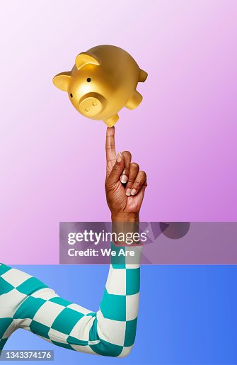 Piggy bank balancing on finger Piggy bank balancing on finger