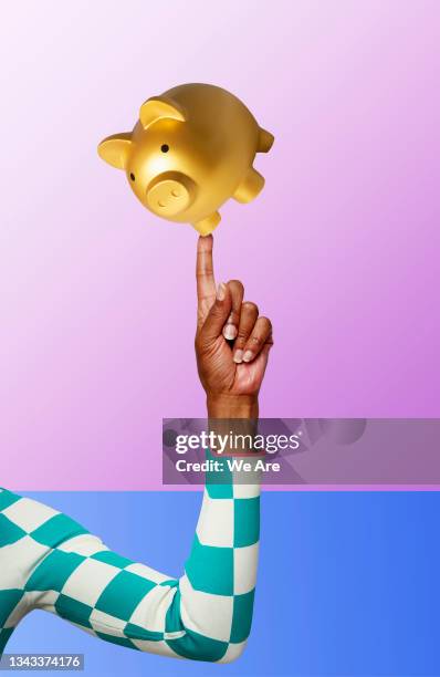 piggy bank balancing on finger - spaarpot financieel item stockfoto's en -beelden