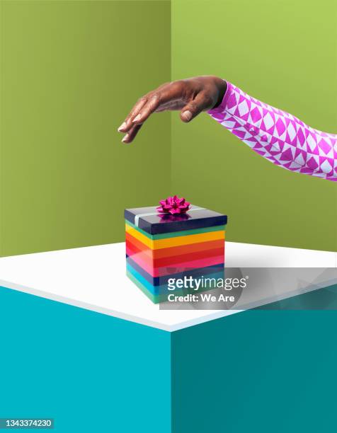 hand above colourful gift - human arm stock pictures, royalty-free photos & images