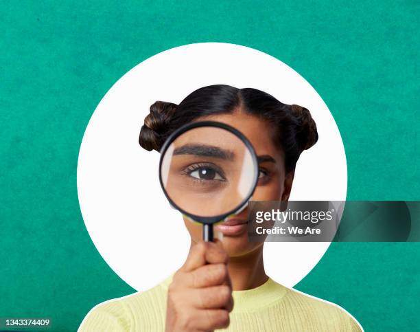 woman looking through magnifying glass - scoperta foto e immagini stock