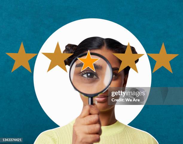 woman looking through magnifying glass at 5 stars - customer engagement stockfoto's en -beelden