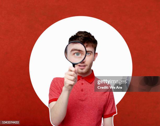 man looking through magnifying glass - curiosity foto e immagini stock