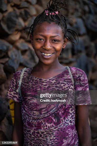 afrikanisches mädchen, das wasser aus dem brunnen trägt, äthiopien, afrika - traditional ethiopian girls stock-fotos und bilder