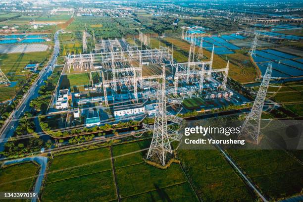 aerial view of electricity pylons and a big  electrical substation at shanghai city,china - power grid stock-fotos und bilder