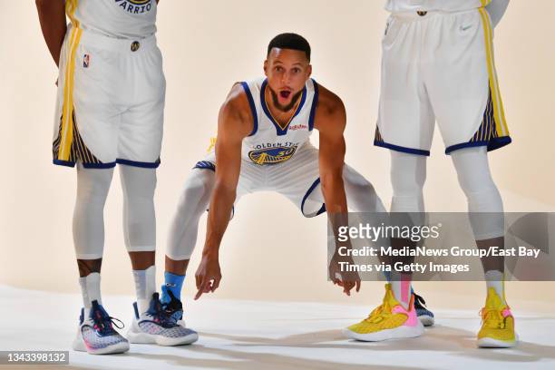 Golden State Warriors' Stephen Curry points to the shoes of Golden State Warriors' Damion Lee , left, and Golden State Warriors Andre Iguodala during...