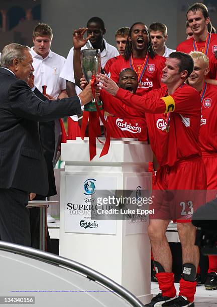 Liverpool captain Jamie Carragher is handed the trophy after his teams UEFA Super Cup victory over CSKA Moscow at the Stade Louis II, in Monaco, on...