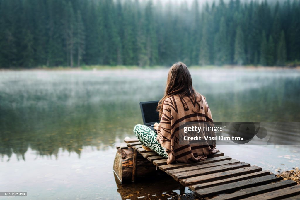 Woman Relaxing In Nature And Using Technology