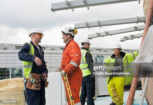 construction workers in discussion - protective workwear stock-fotos und bilder