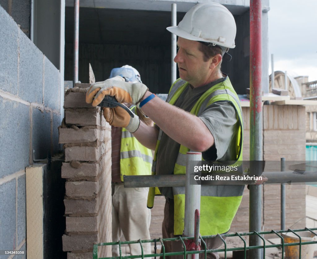 Bricklayers build a wall.