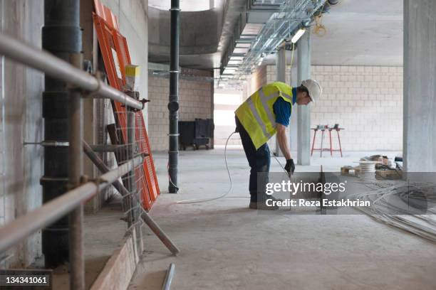 electrician unwinds electrical cable - casco herramientas profesionales fotografías e imágenes de stock