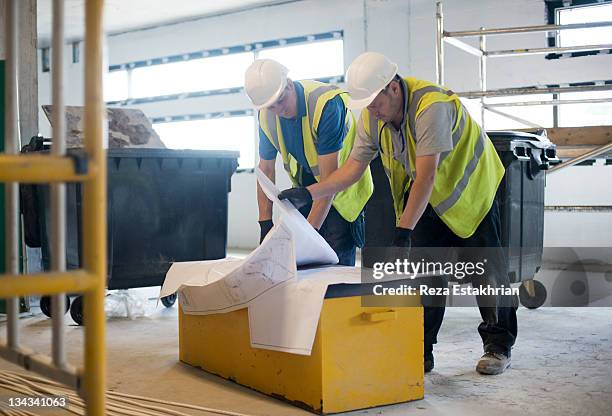 engineers check building plans - inarcare la schiena foto e immagini stock