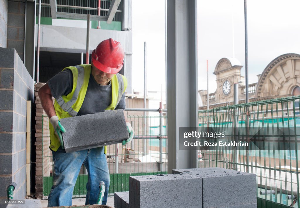 Construction worker moves cinder block on site